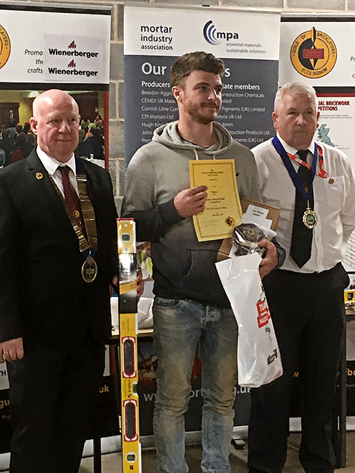 Junior winner 2019 - Junior section winner, Tom Taylor, Wiltshire College, receives his awards from president of the Guild of Bricklayers, Kevin Harold (left) and chair of the guilds north west section, Jeff Dunn
