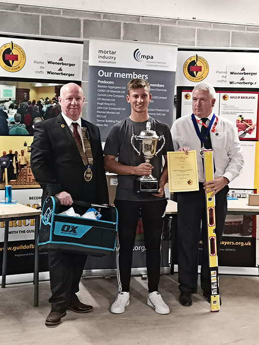 Senior winner 2019 - President of the Guild of Bricklayers, Kevin Harold (left) and chair of the guilds north west section, Jeff Dunn, present senior winner, Adam Batty of Barnsley College with his awards