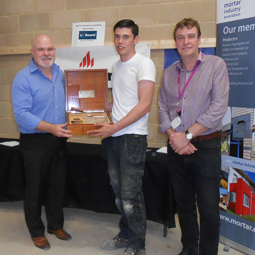 Guild of Bricklayers president, Phil Vine-Roberts (left) and the Brooklands College head of construction, Neil Houldey present the junior heat award to Tiyler Pearce of Brooklands College
