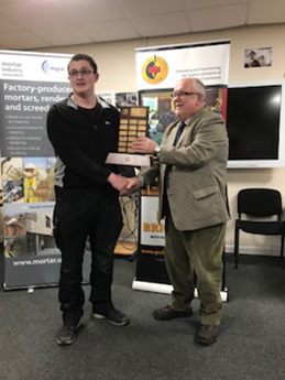 Liam McGinley of the NPTC Group, Neath, receives his senior category trophy from the president of the Guild of Bricklayers, Phil Vine Roberts.